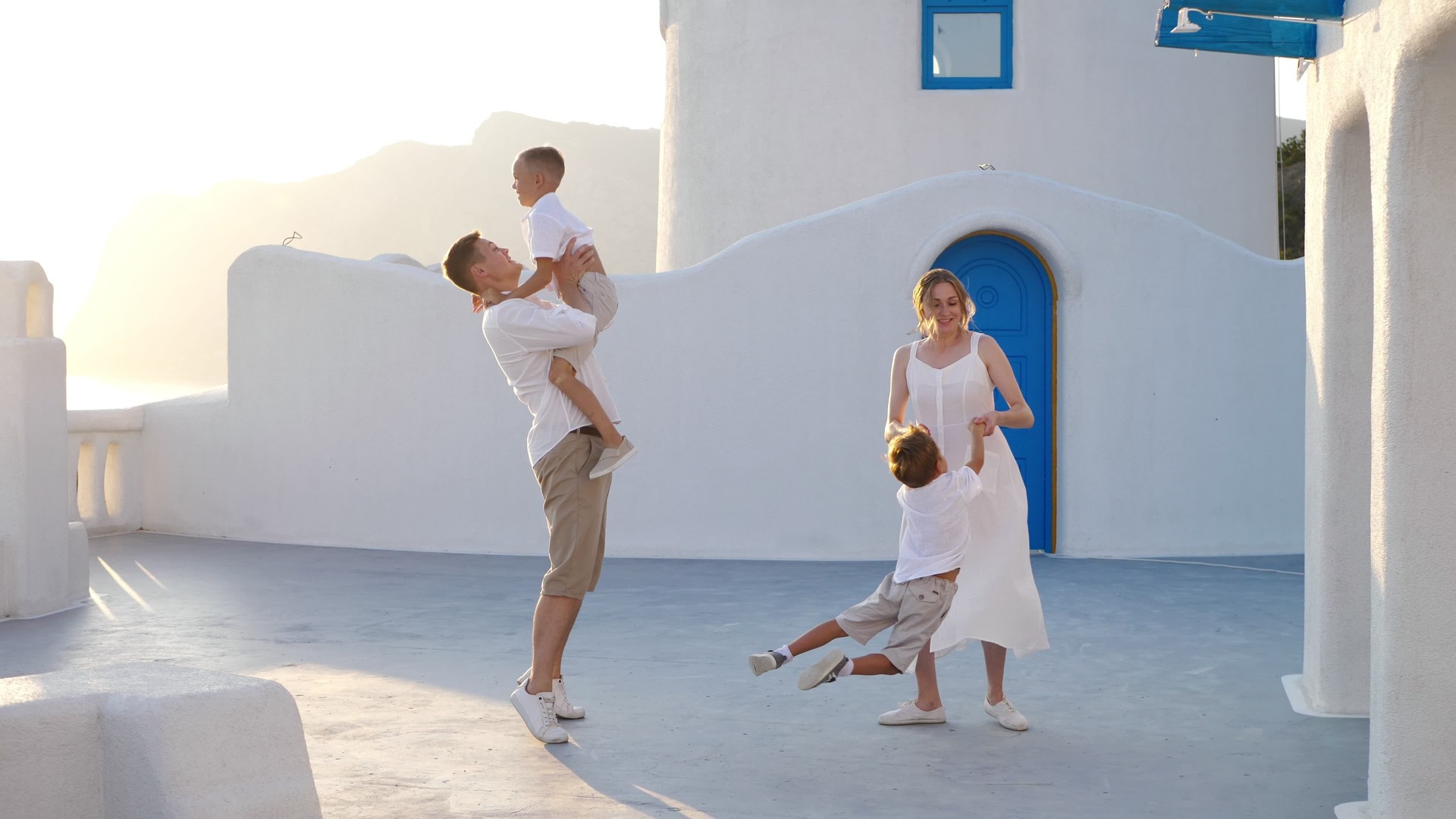 Happy family with children on vacation in Santorini, Greece. Parents have fun with their children.